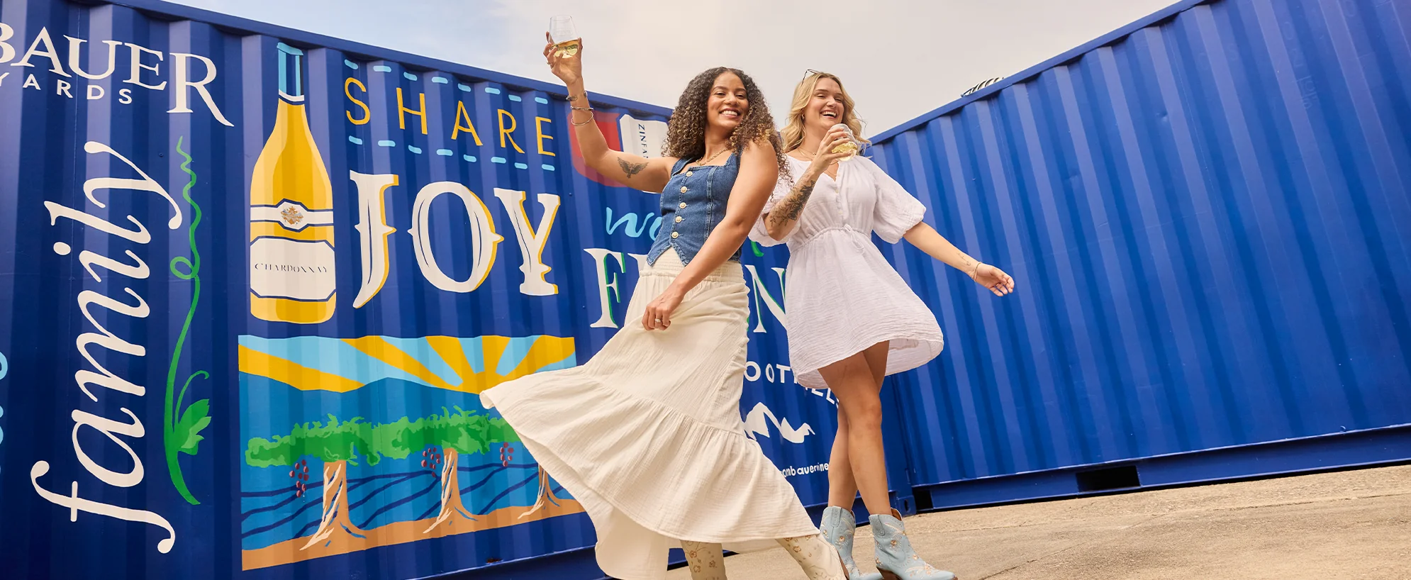 Two girls dancing in front of Rombauer Sierra Foothills mural