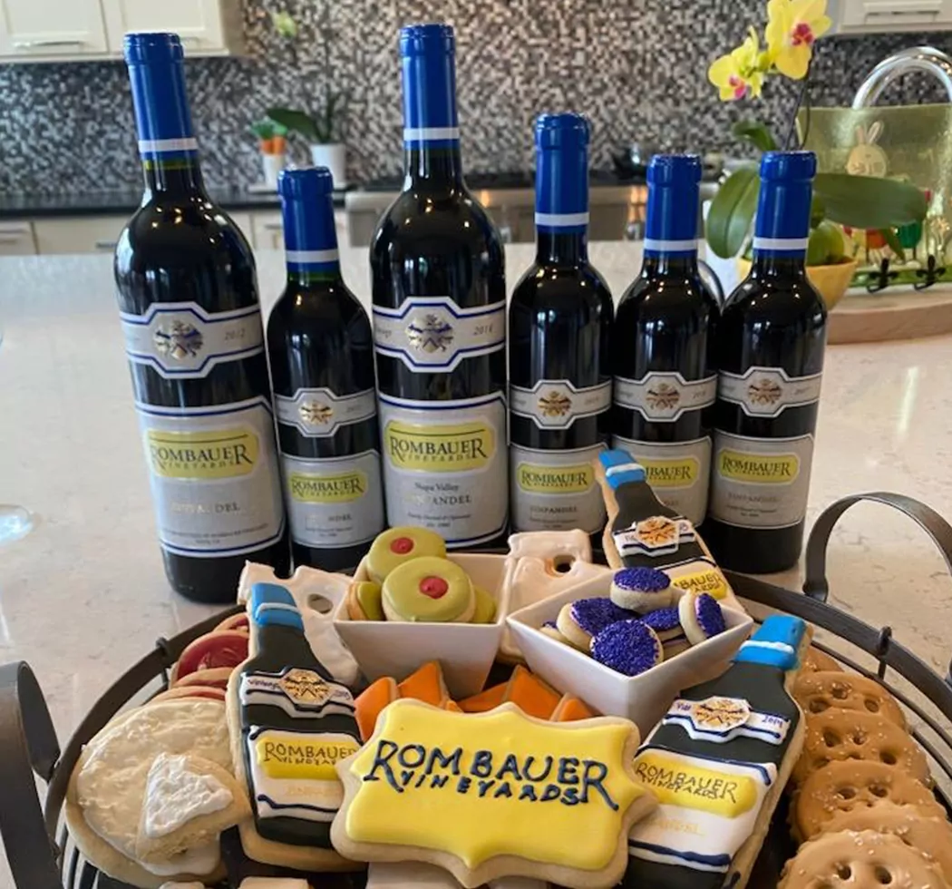 A Club Member with multiple Zinfandels and a plate of Rombauer cookies