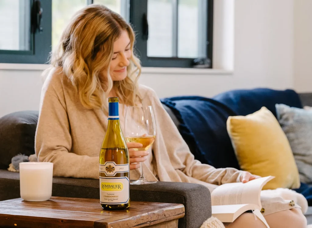 Woman reading a book and drinking Rombauer wine