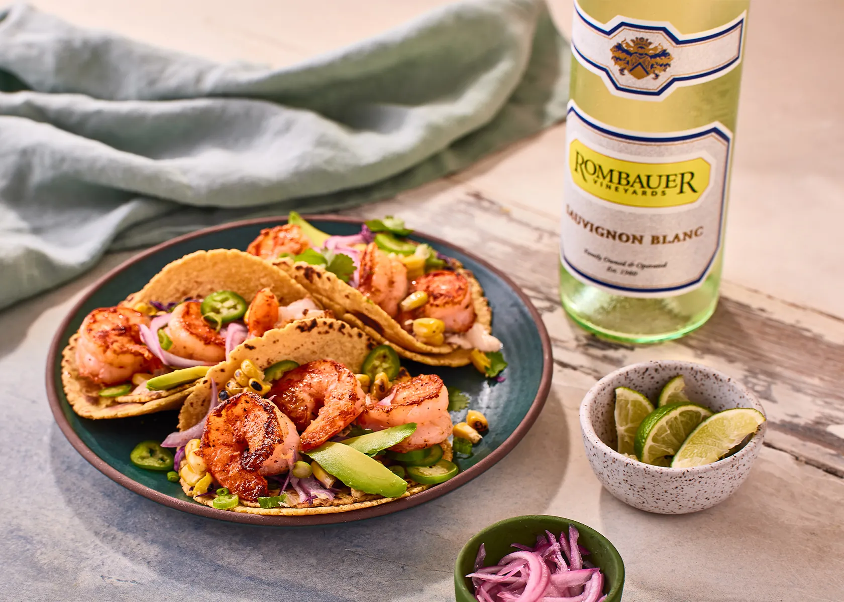 Shrimp Tacos on a plate with a bottle of Rombauer Sauvignon Blanc