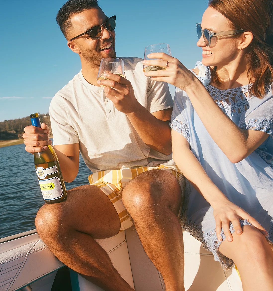 Man and Woman cheersing on a boat with Rombauer Chardonnay