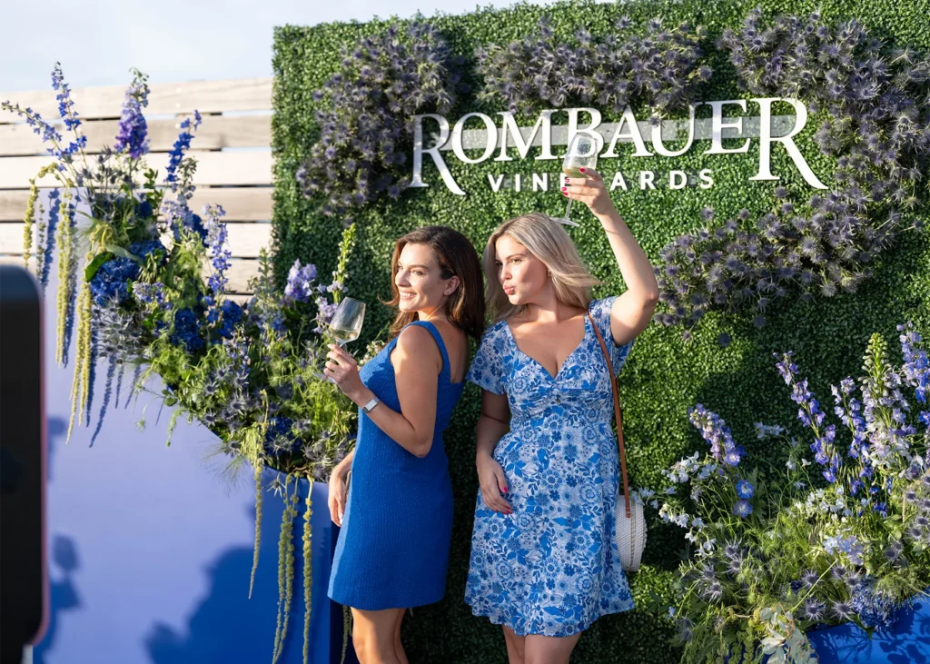 People talking and laughing with glasses of Rombauer Wine